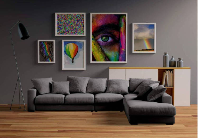 Quadros Nas Cores Do Arco-Íris. Sala de parede cinza, sofá cinza, chão de madeira, aparador branco e quadros coloridos