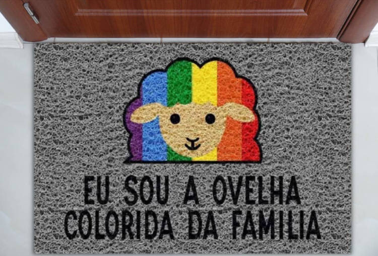 Tapete Divertido. Tapete cinza para porta de entrada com desenho de ovelha colorida e frase "eu sou a ovelha colorida da família"