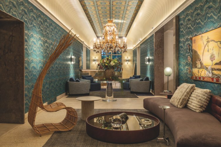 Casacor-Sao-Paulo-2025-2 Bar com apapel de parede verde, sofá marrom, lustre, poltronas azuis e mais