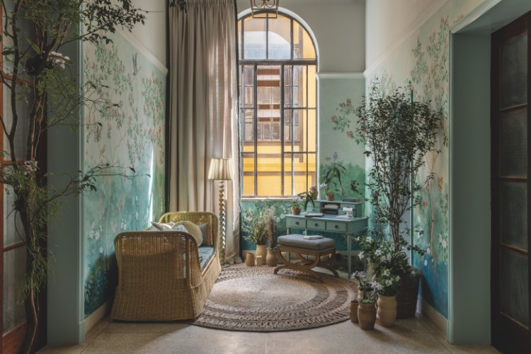 Casacor-Sao-Paulo-2025-11 Jardim de inverno com papel de parede de plantas, plantas, móveis artesanais, tapete marrom