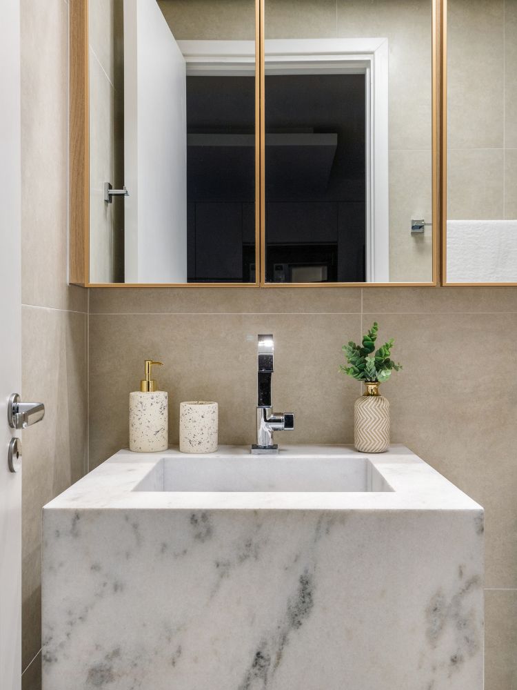 Estudio-De-29-M2-8 Banheiro com espelho, pia de mármore e parede bege