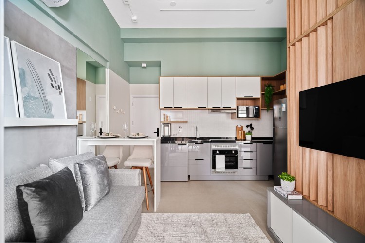 Apartamento-De-37-M2-12 Sala integrada com cozinha com paredes verdesm armários brancos e cinzas