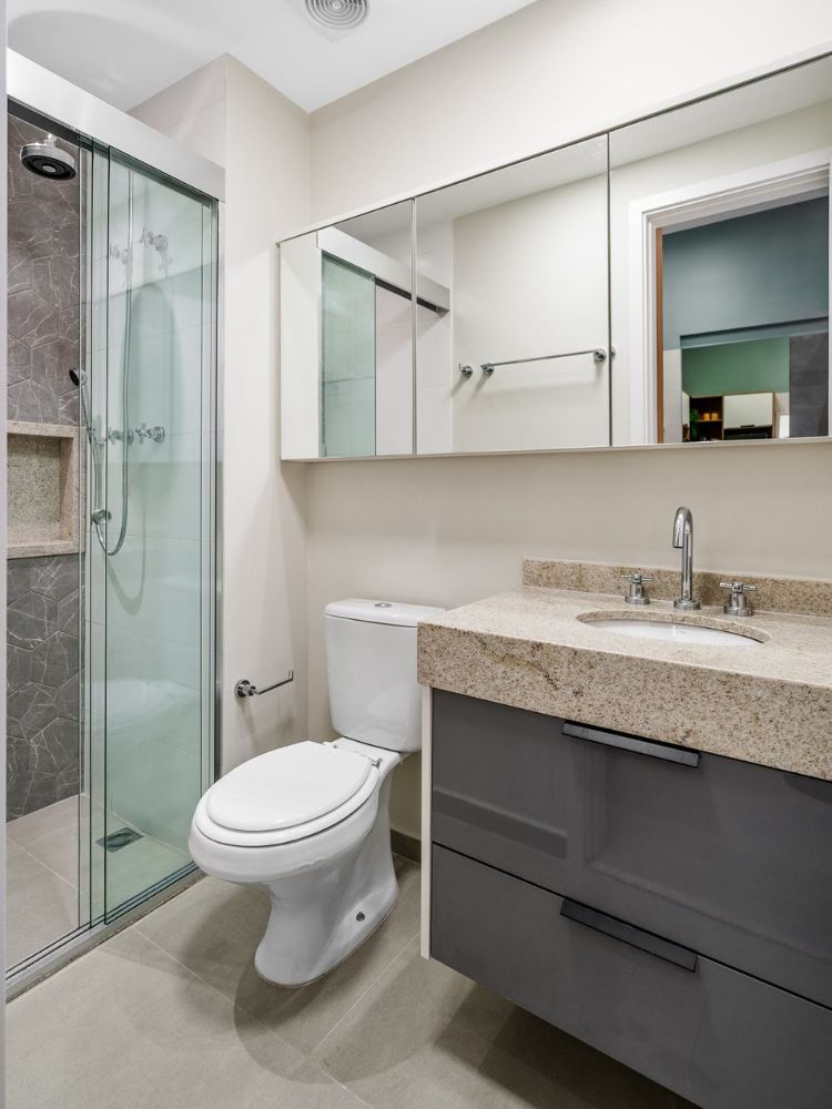 Apartamento-De-37-M2-2 Banheiro com espelho, box e gabinete cinza