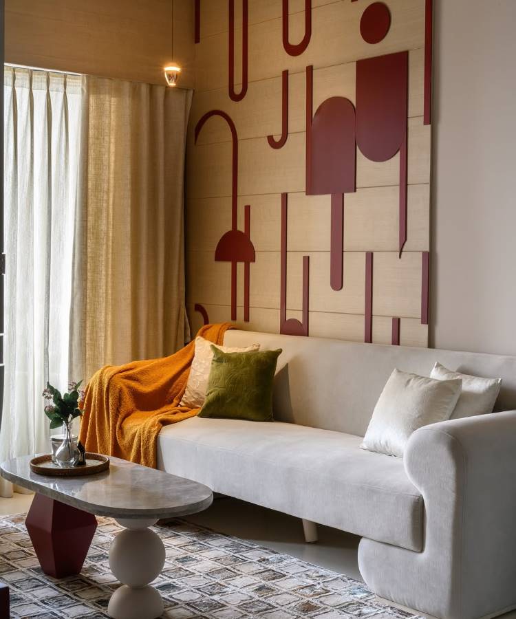 Almofadas-Para-Sofa-17 Uma sala moderna com sofá claro, manta laranja e almofadas para sala verde-oliva e creme. A parede destaca-se com painéis de madeira e formas geométricas em tom terroso. Uma mesa de centro de mármore e base escultórica complementa o ambiente elegante. Cortinas neutras completam a decoração.