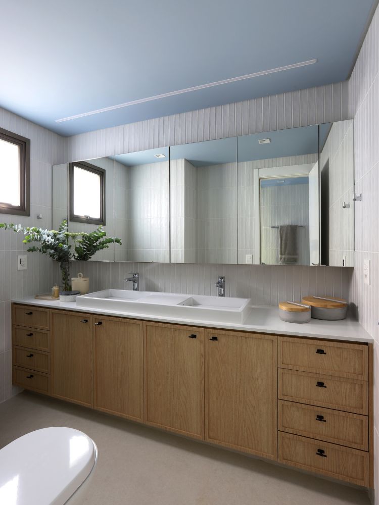 Apartamento-Decorado-158-M2-10 Banheiro amplo com móvel de madeira e espelhos