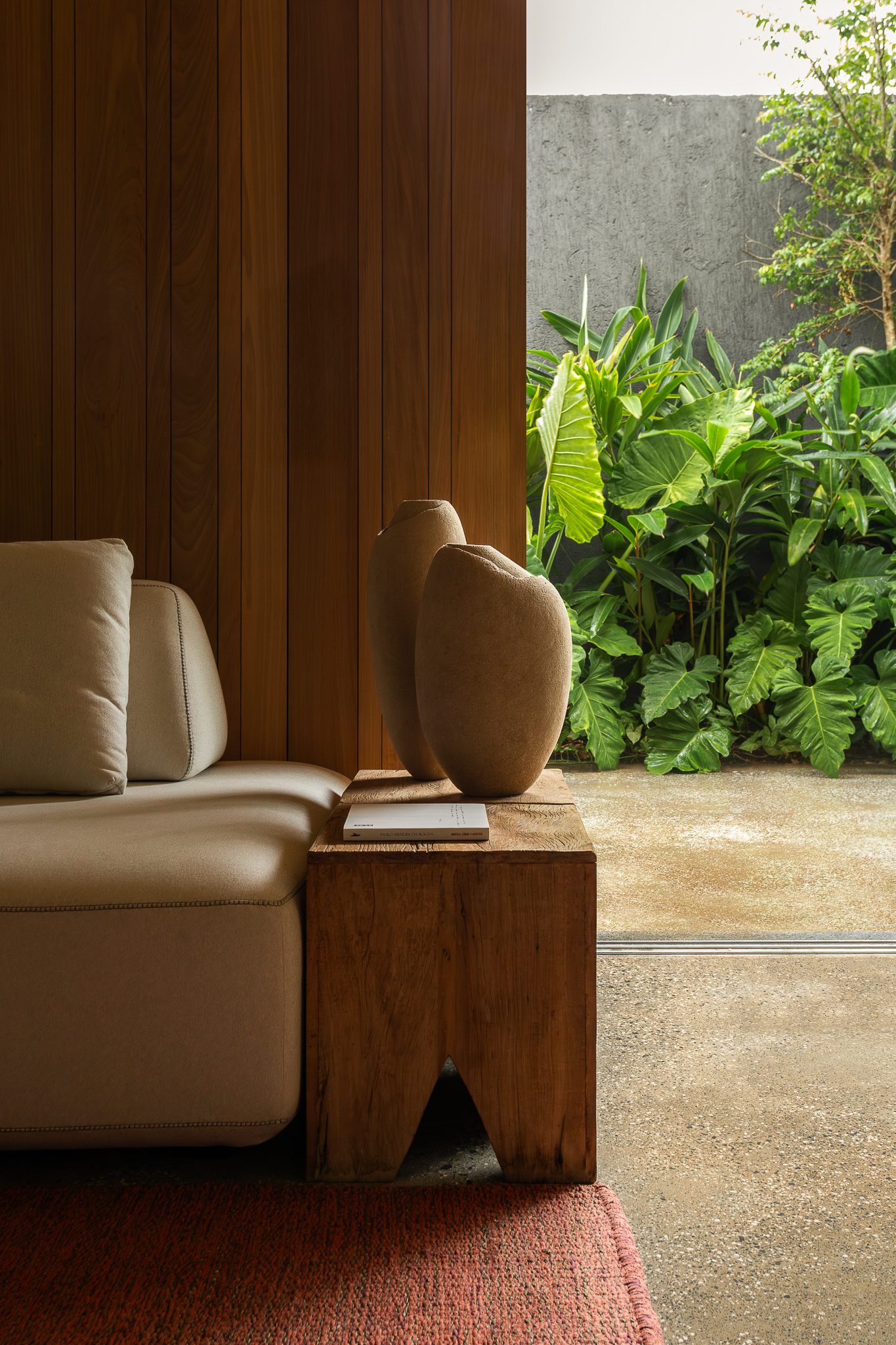 Materiais naturais na Casa Jasmim, com concreto lapidado, madeira aparente e paredes de acabamento rústico