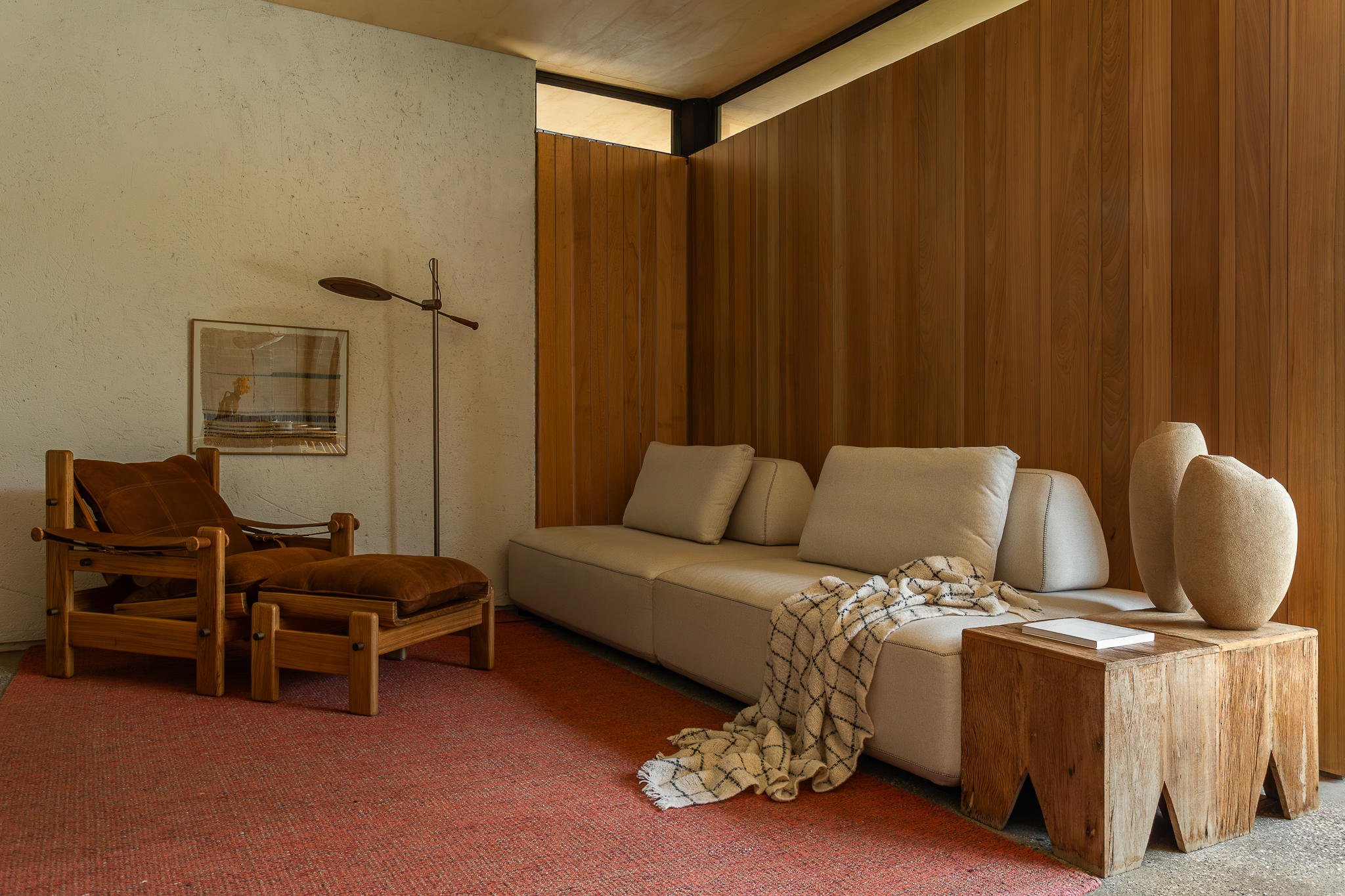 Sala integrada da Casa Jasmim se conecta ao pátio, com aberturas e materiais naturais