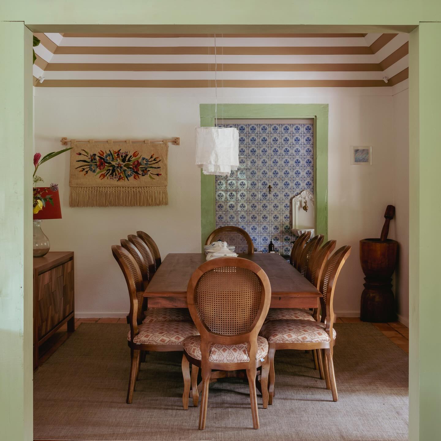 Sala de jantar de casa centenária reformada com piso original preservado, paredes coloridas e elementos decorativos de época