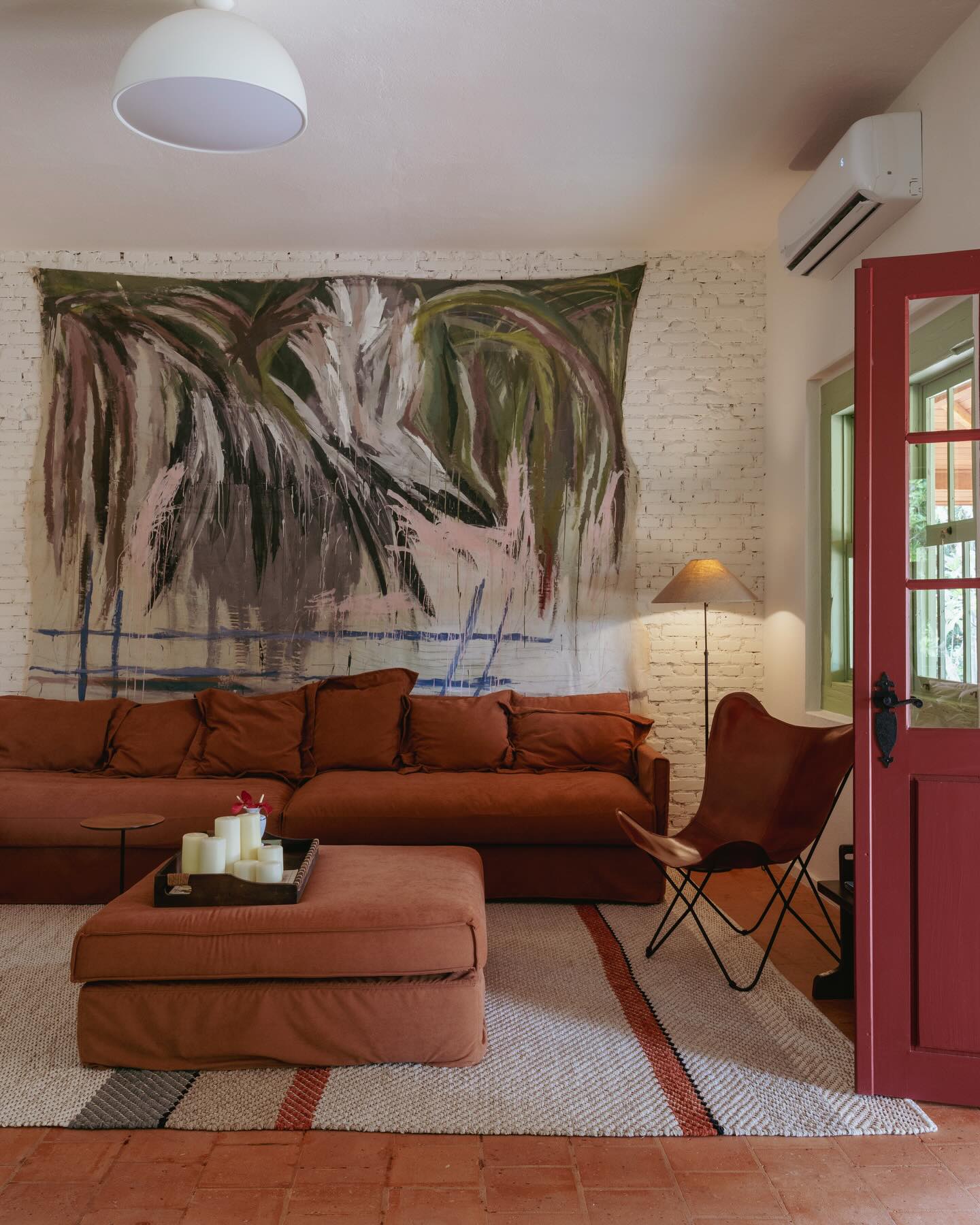 Sala de estar aconchegante com móveis dispostos para convivência, arte brasileira e atmosfera acolhedora em casa antiga reformada