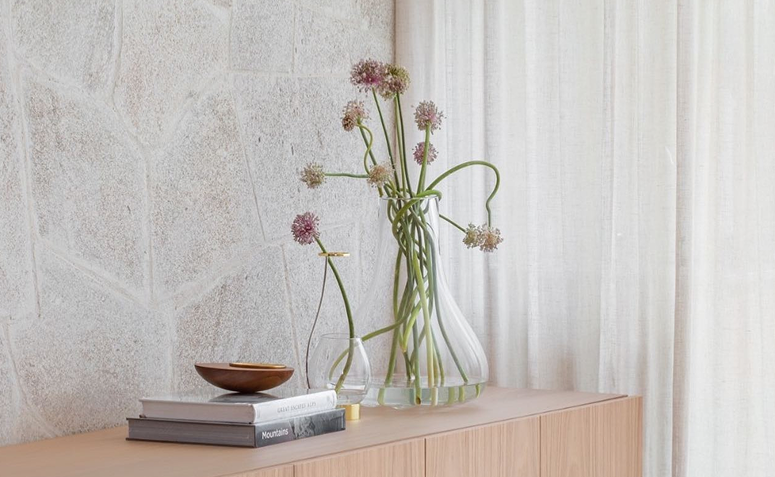 Flor de alho em vaso de vidro compondo aparador com decoração natural e elegante