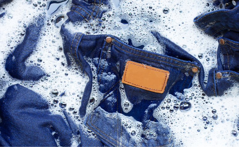 Jeans submerso em uma mistura de água e sabão.