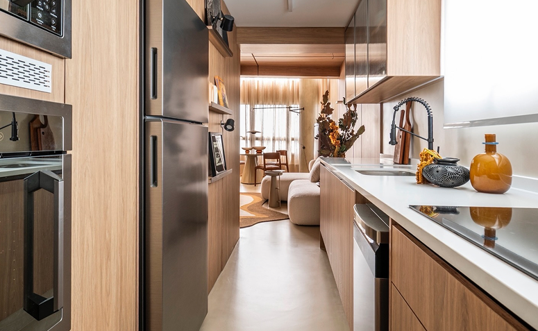 Cozinha com layout linear e circulação estreita, integrada à área social, exigindo organização para funcionar bem no dia a dia.