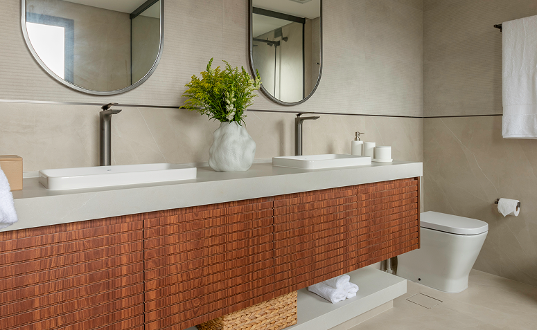 Banheiro de casal com duas cubas, bancada ampla e armário planejado, pensado para o uso simultâneo no dia a dia.