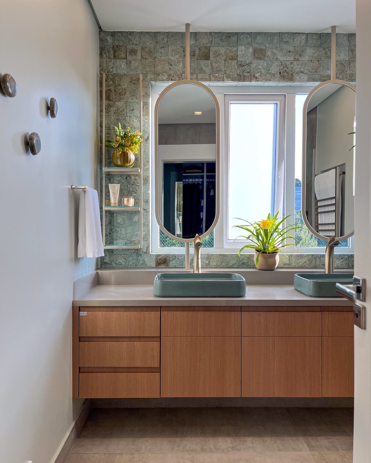 Projeto de banheiro de casal com iluminação natural e espelhos amplos.