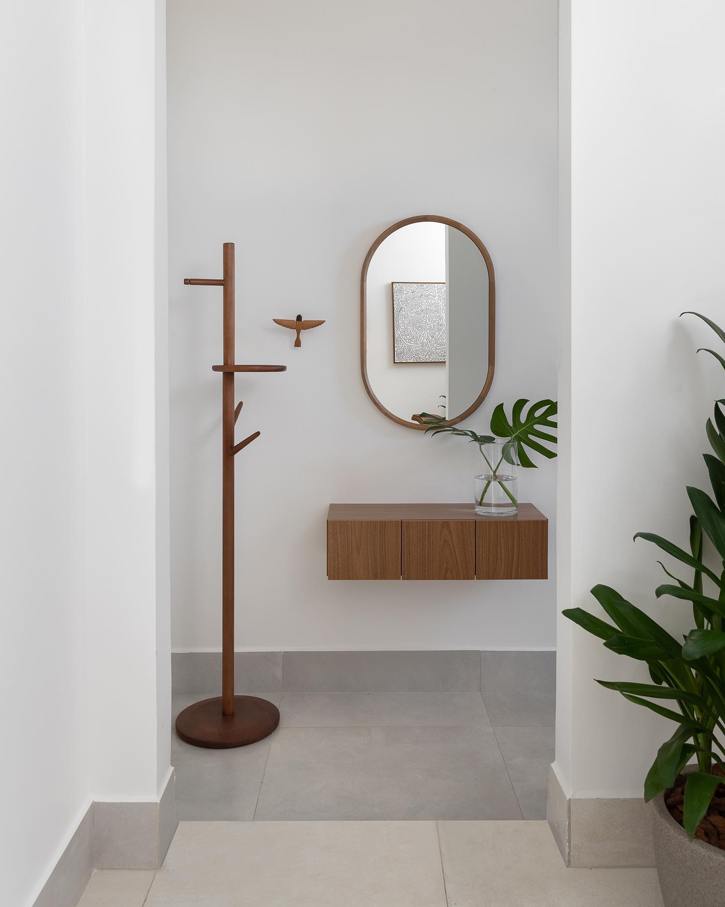 Espelho no corredor em proporção adequada ao espaço, valorizando a circulação.