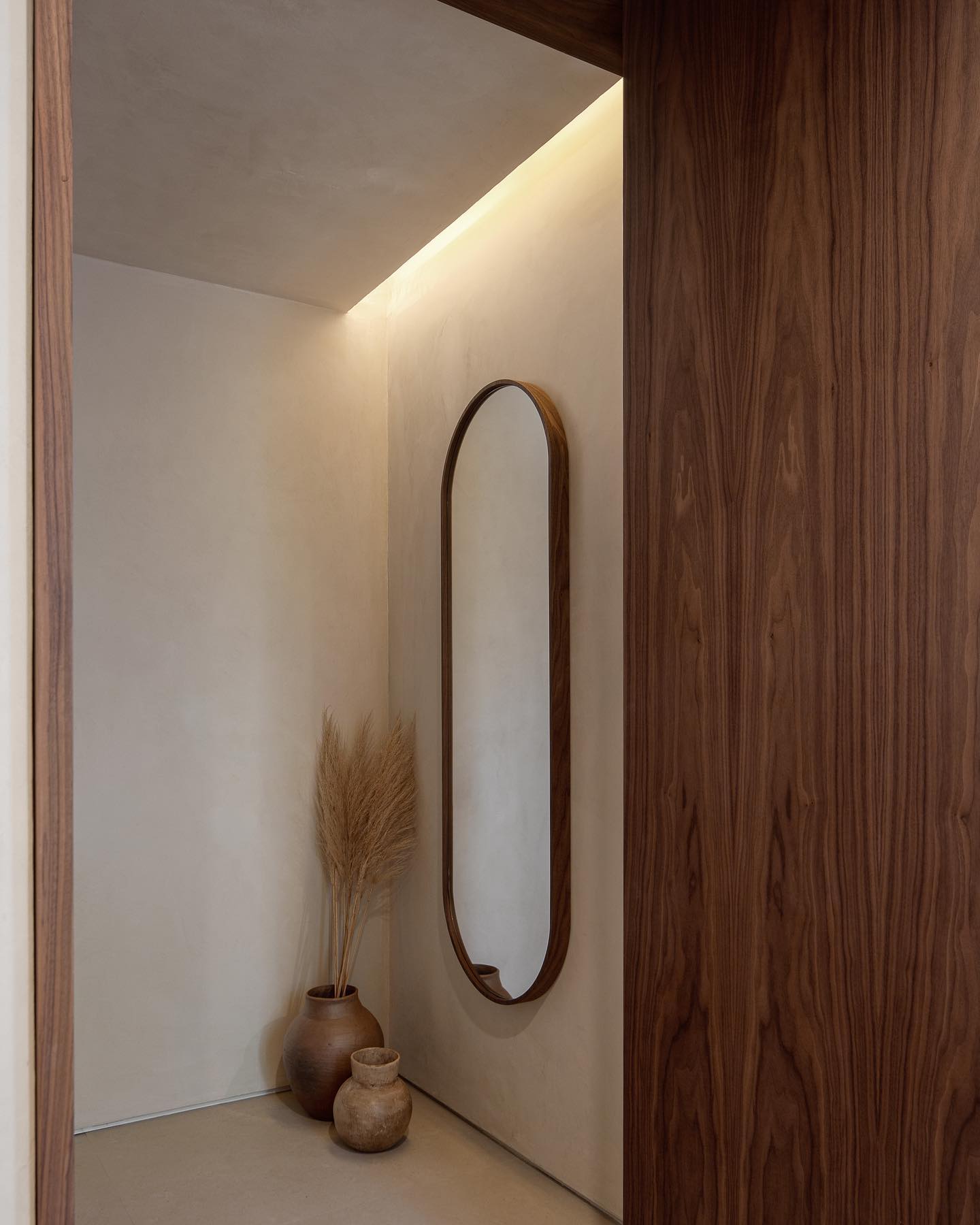Espelho como ponto focal na decoração do corredor.