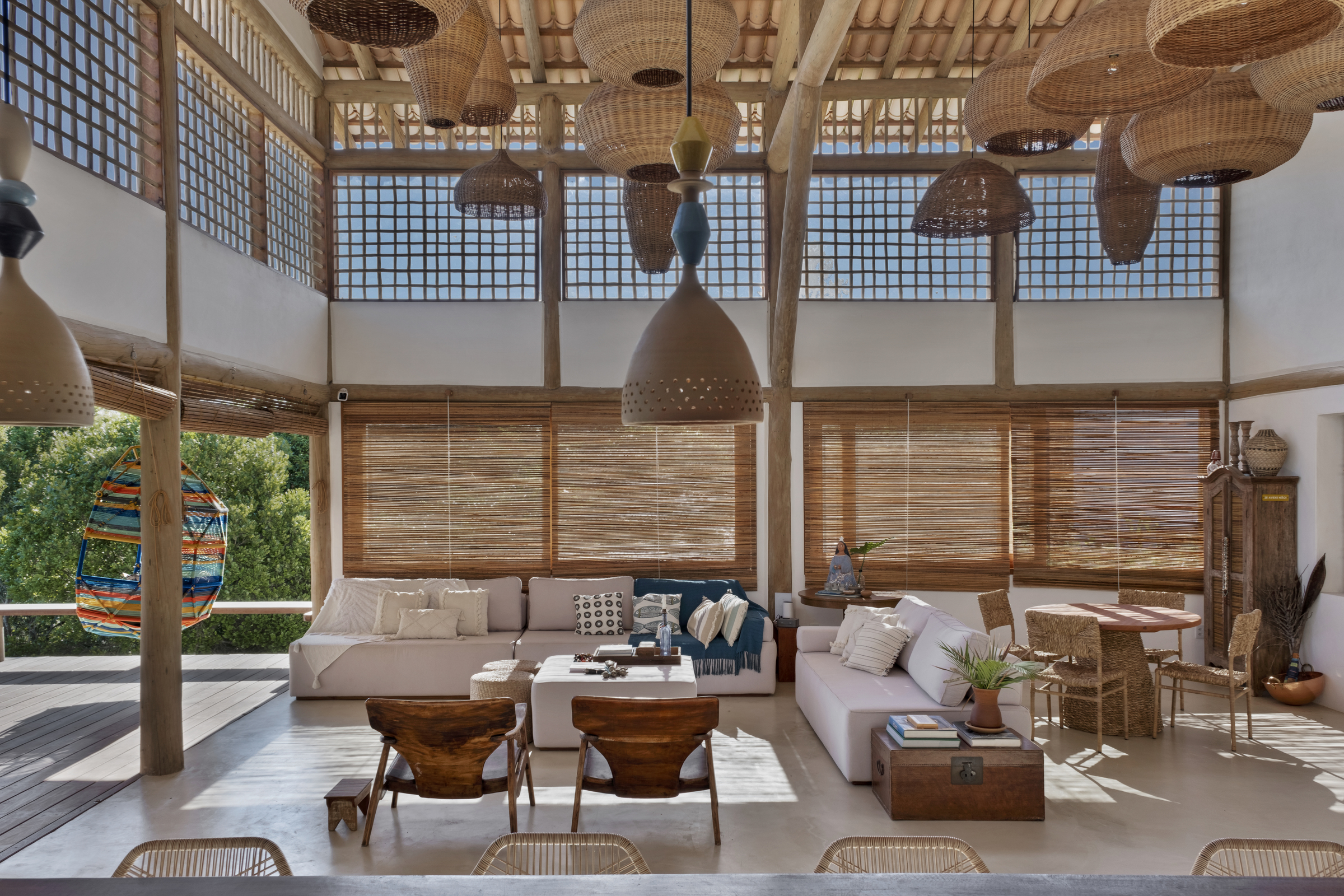 Detalhe de materiais naturais em casa de praia, com madeira aparente, cimento queimado e acabamentos artesanais