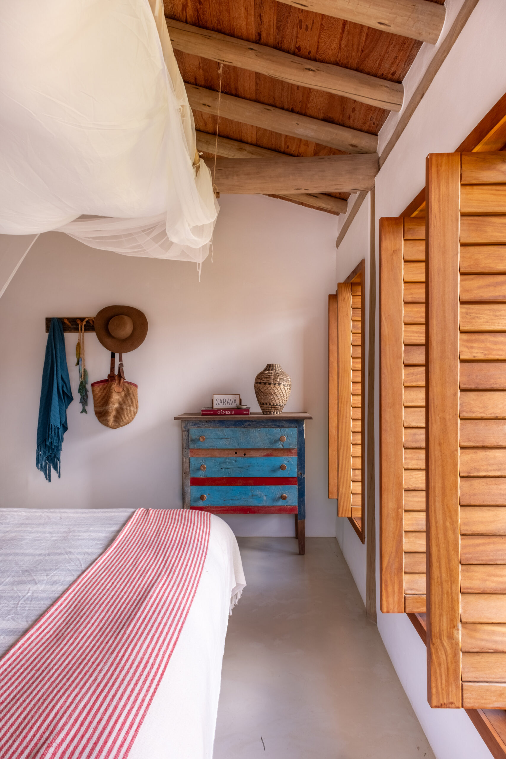 Quarto de casa de praia em Trancoso com materiais naturais, iluminação suave e atmosfera acolhedora integrada ao clima tropical