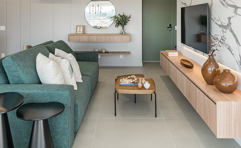 Sala de estar com base neutra, móveis claros e ponto de cor em sofá verde