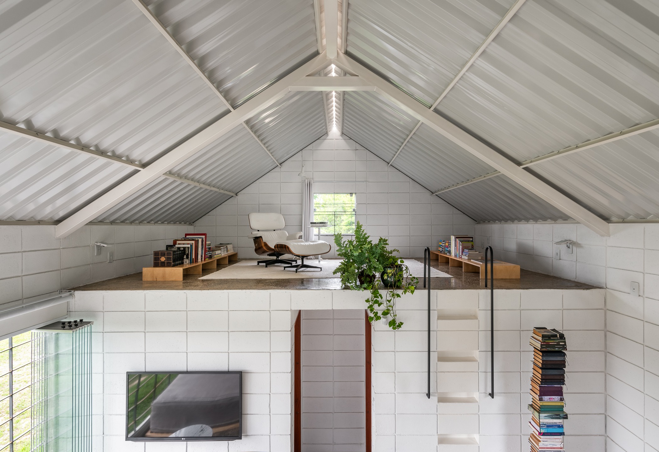 Vista aérea da parte interna da casa, evidenciando a sala de leitura no mezanino.
