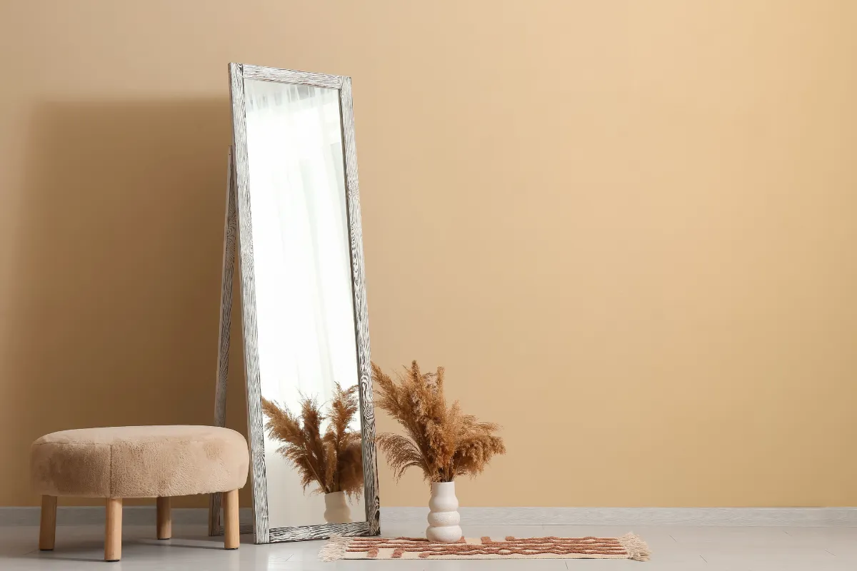 Espelho-Decorativo-1 Espelho vertical do lado de um vaso e um banco pequeno