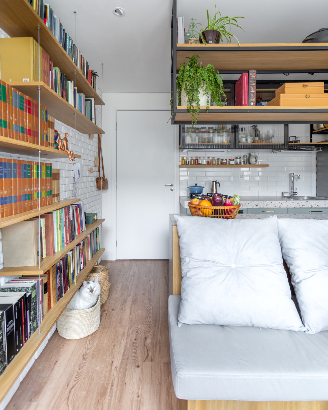 Área social de apartamento pequeno com sofá de canto sob medida e mesa desmontável