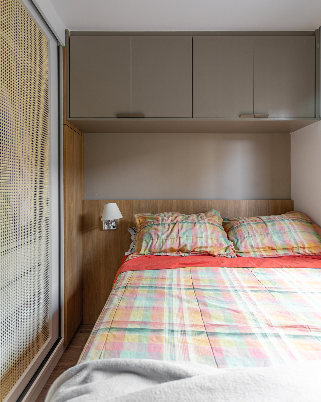 Quarto de casal em apartamento de 25 m² com armários de portas de correr e acabamento em freijó