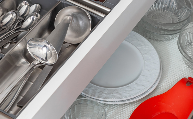 Gaveta de cozinha organizada com utensílios de uso diário à frente