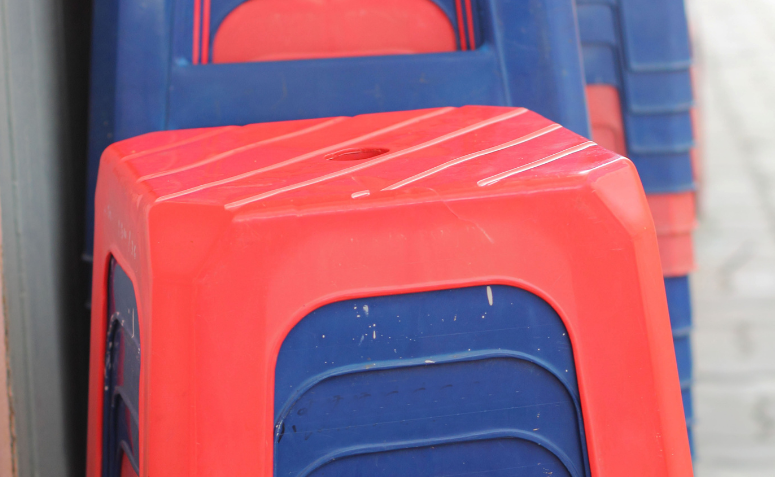 Bancos de plástico empilhados mostrando o furo central no assento