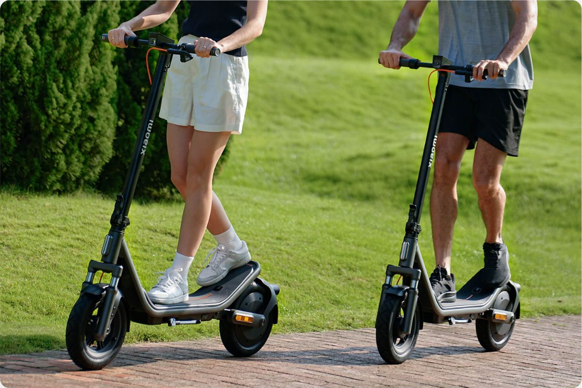 Duas pessoas andam de Xiaomi Electric Scooter 6