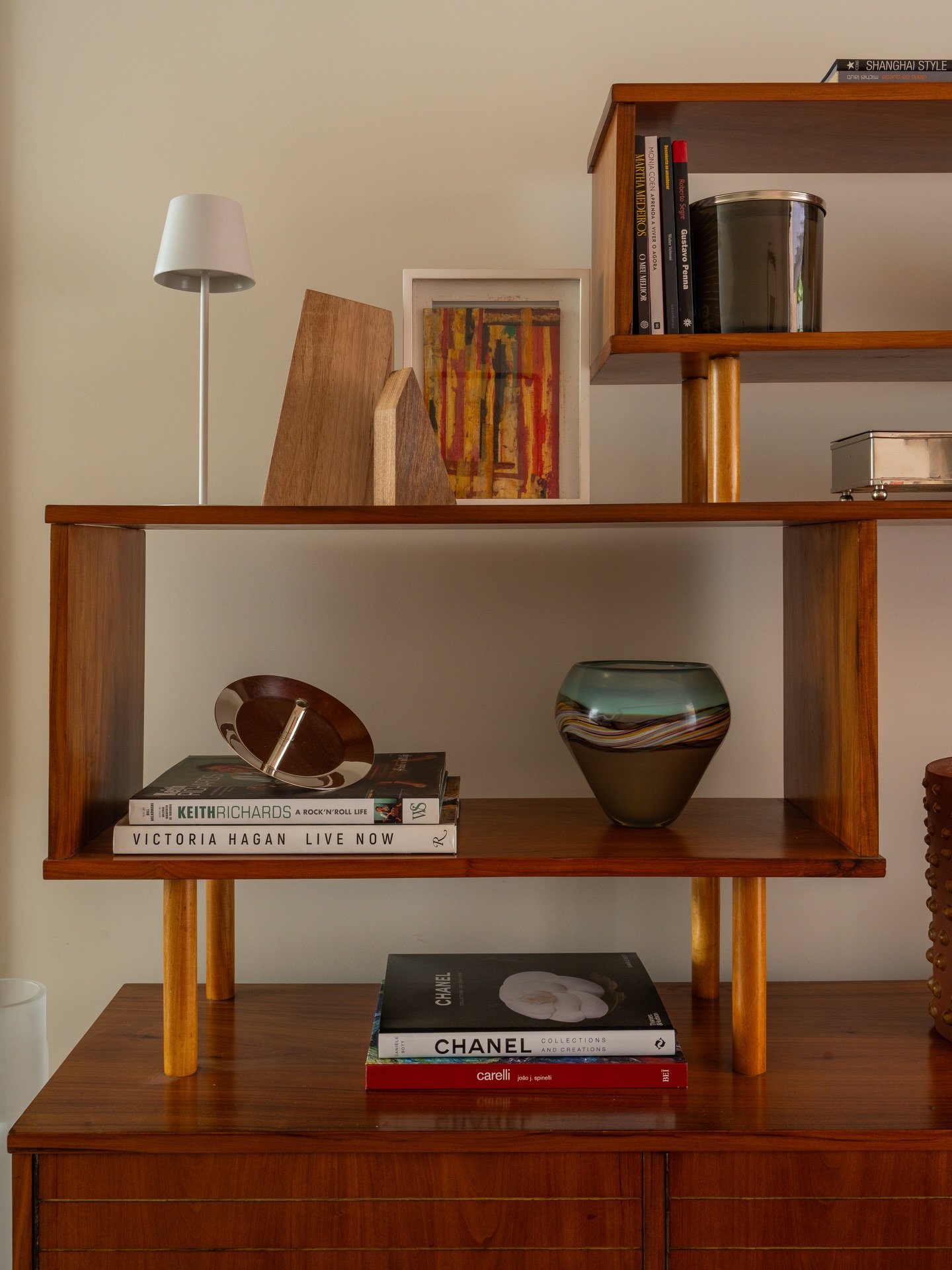 Estante de madeira com livros e objetos de decoração nas prateleiras.