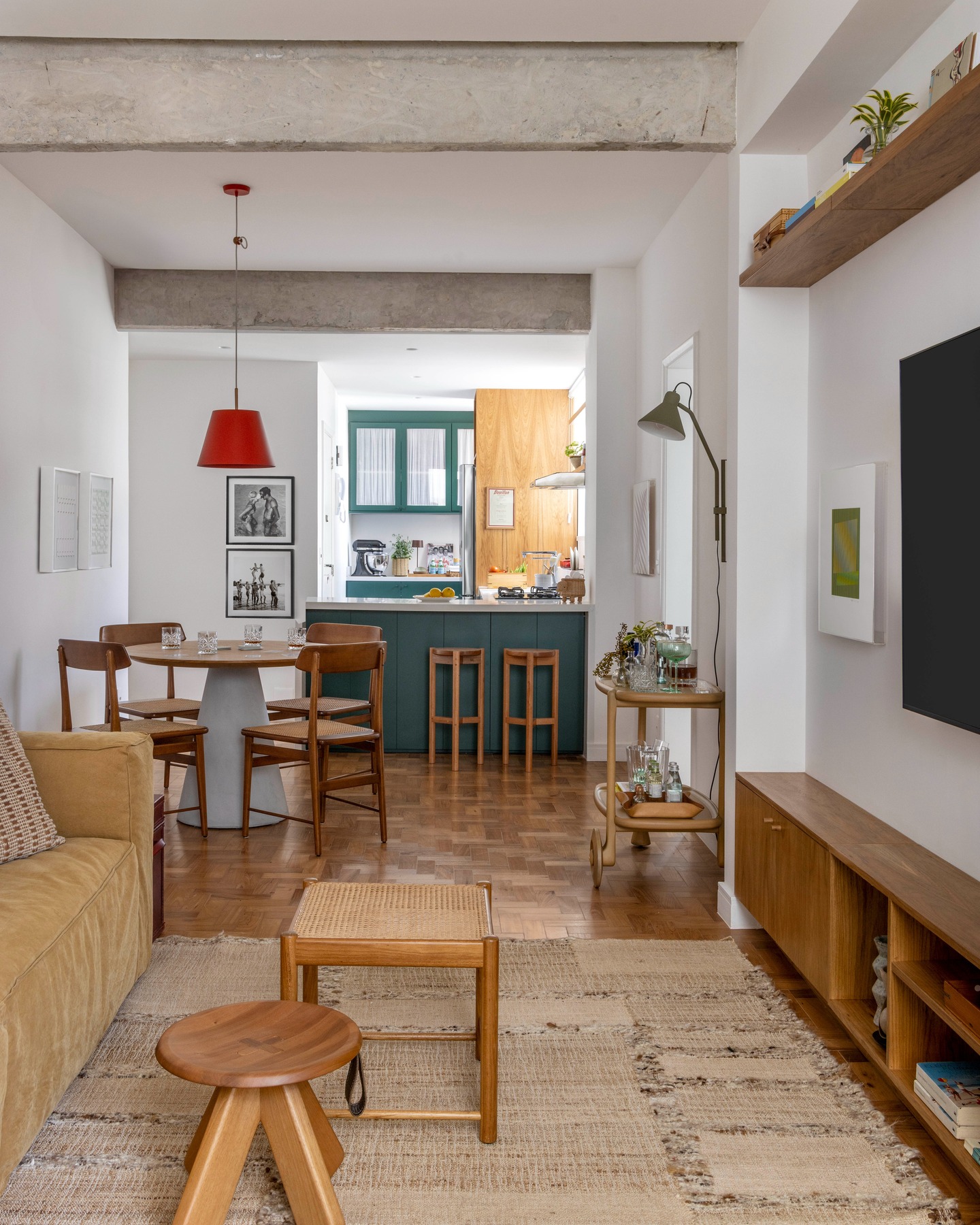 Vista da área social do apartamento, abrangendo sala de estar, sala de jantar e cozinha.