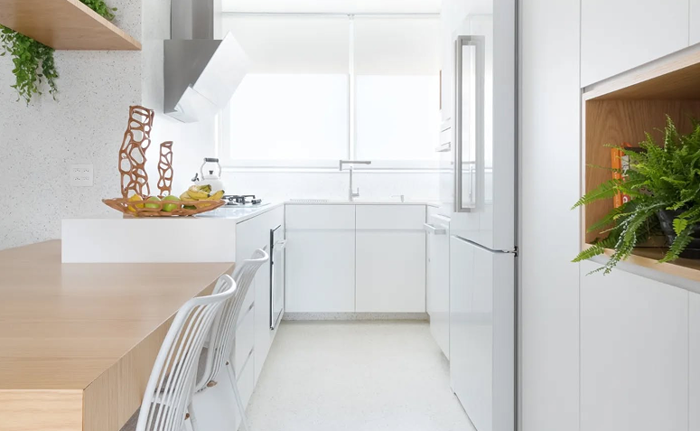 cozinha branca com armários claros e elementos naturais criando ambiente leve e organizado