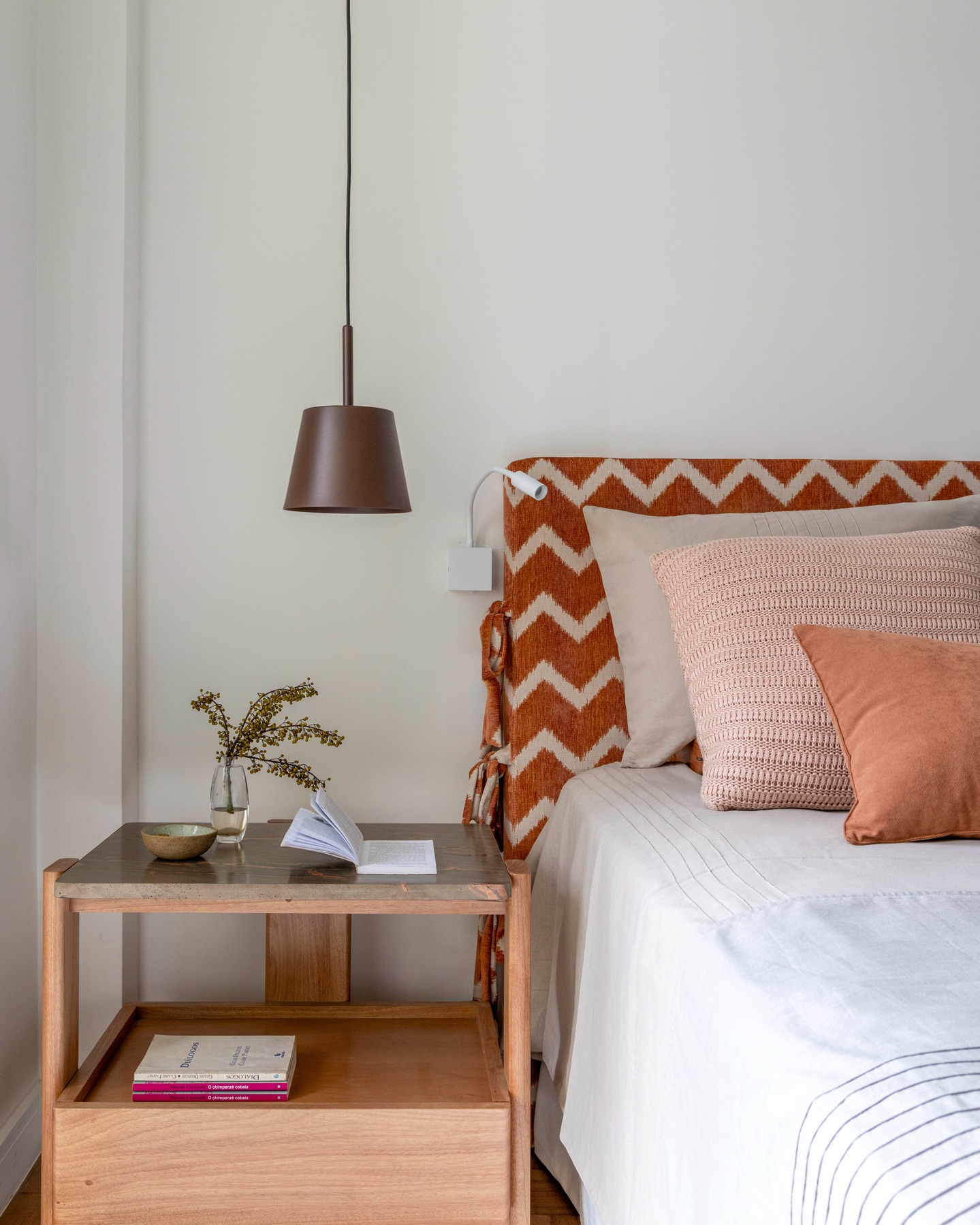 Cama do quarto com composição de tons terrosos.