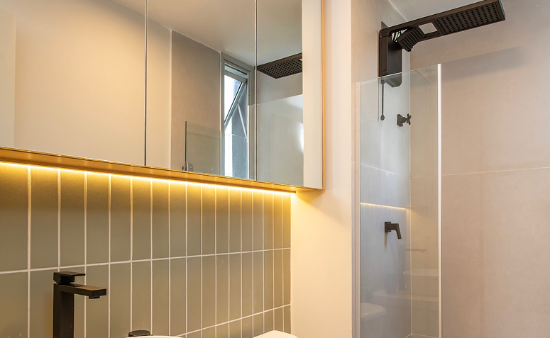 Chuveiro elétrico em banheiro moderno, destacando manutenção para evitar desperdício de água