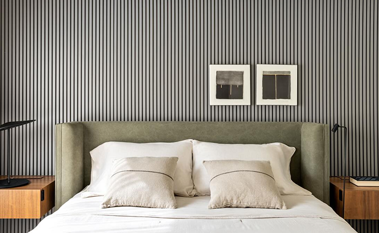 Cama arrumada com lençóis claros em quarto, representando a rotina de cuidados e lavagem da roupa de cama