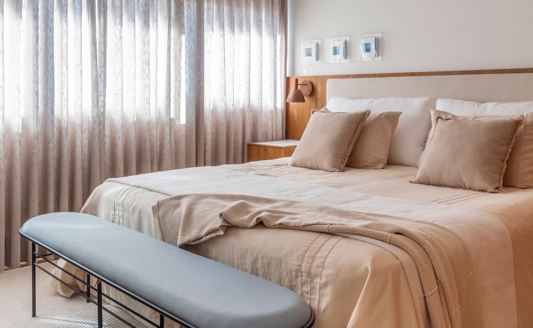 quarto em tons neutros com roupa de cama clara e decoração suave que favorece o descanso.