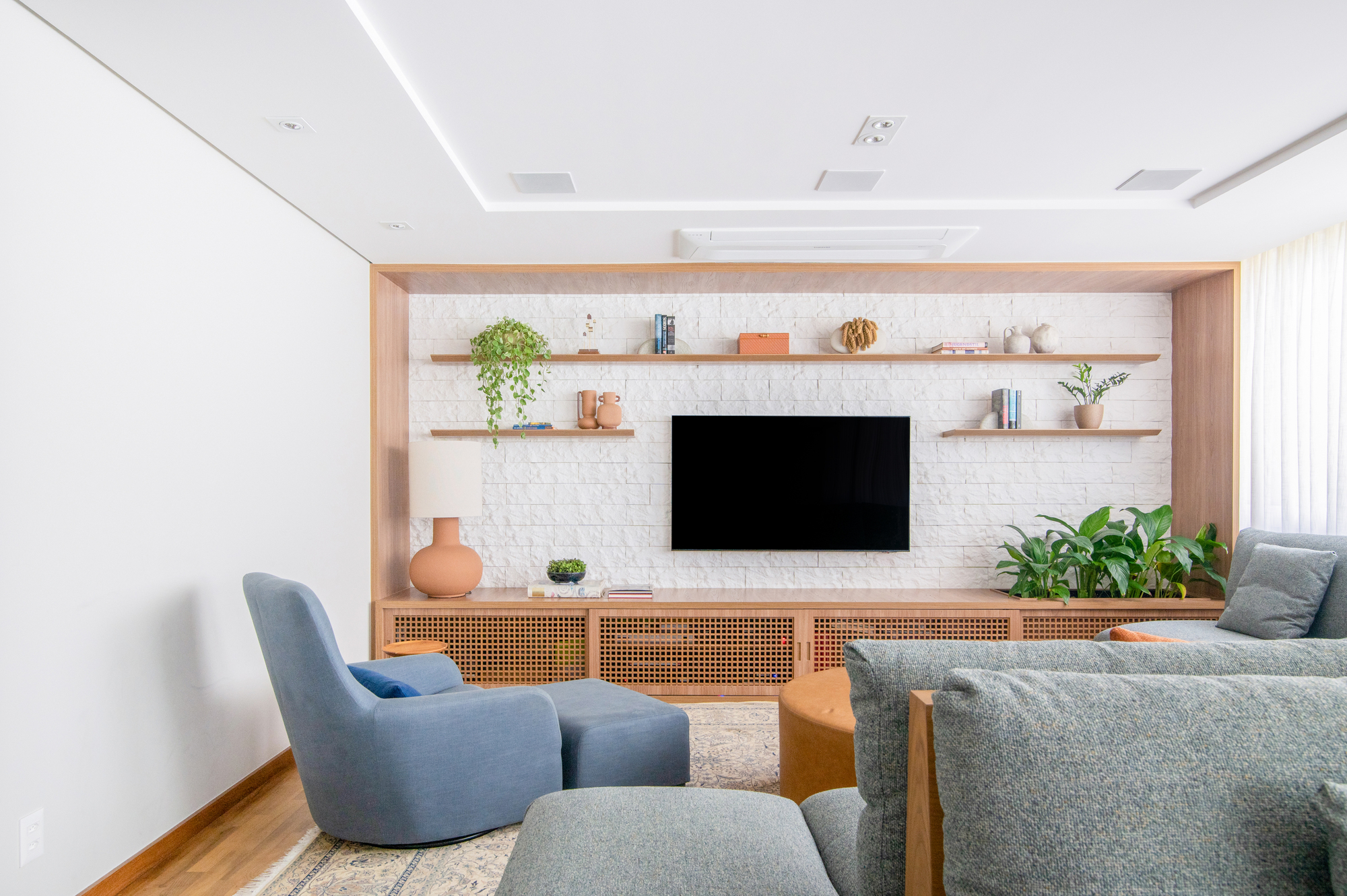 sala de tv ampla e conectada com os ambientes de estar em apartamento.