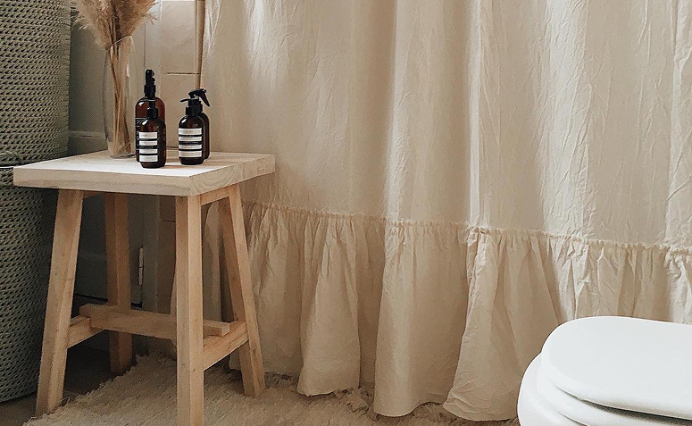 banquinho de madeira organizando itens em banheiro sem armário