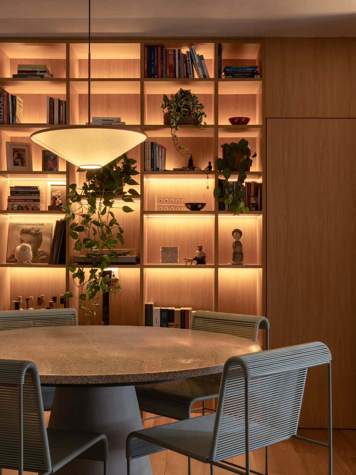 Foto da estante iluminada de madeira na sala de jantar.