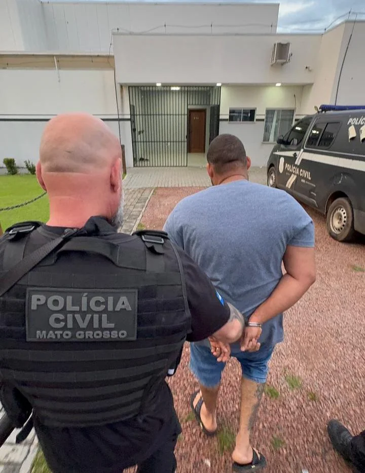 Policial civil levando homem algemado à delegacia