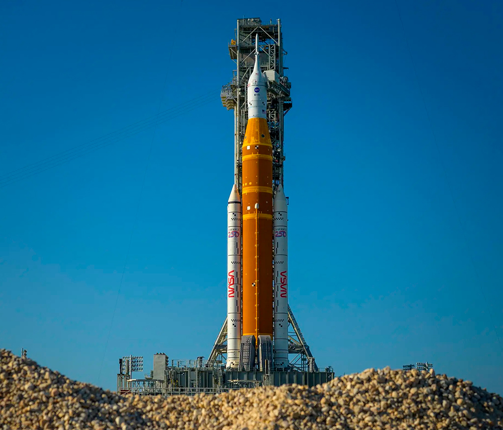 Fotografia do foguete Artemis II Space Launch System (SLS) da NASA e a espaçonave Orion são vistos no topo de uma plataforma de lançamento móvel no Complexo de Lançamento 39B.