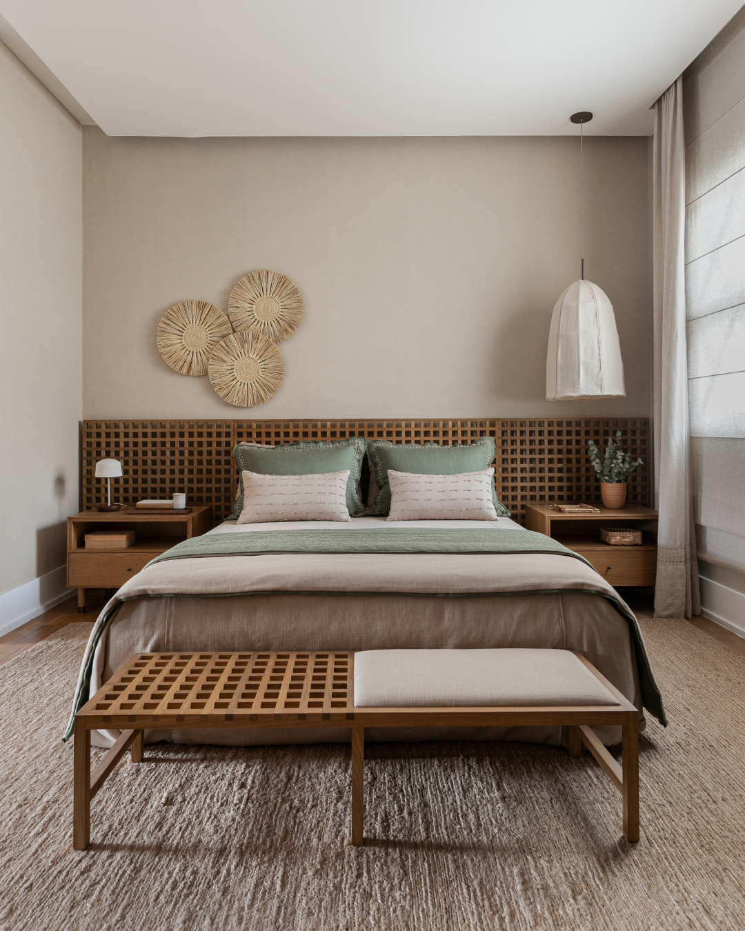 Quarto com cabeceira de madeira, tapete de fibras naturais e roupas de cama em tons neutros