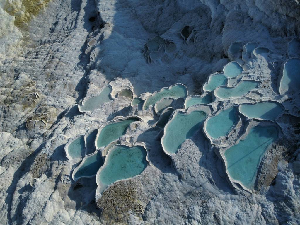 Piscinas naturais em azul claro sobre uma superfície calcária branca Pamukkale Turquia