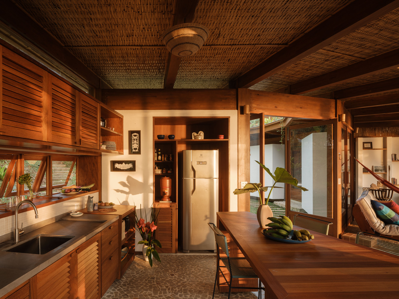 cozinha em casa da figueira com madeira com integração à sala e vista para a natureza