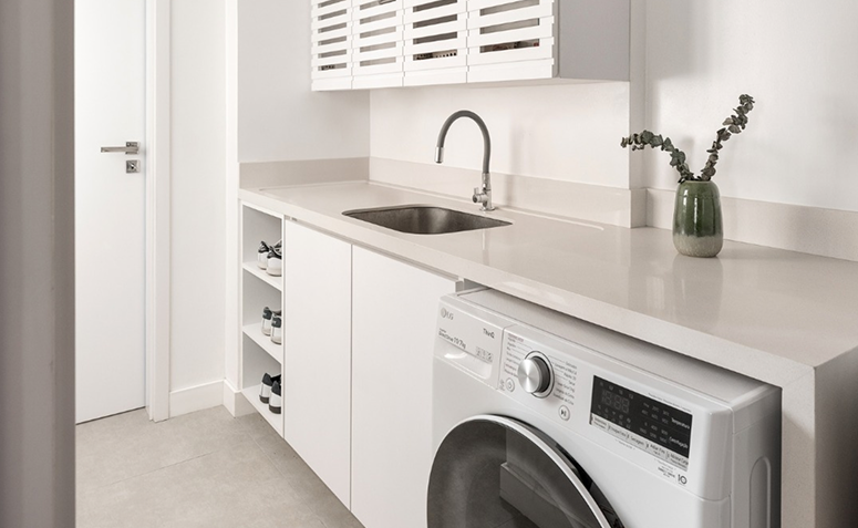 lavanderia branca bem iluminada com sensação de espaço amplo e organizado