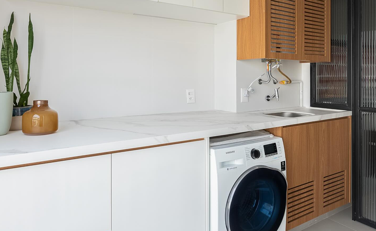 lavanderia branca organizada com detalhes em madeira clara.