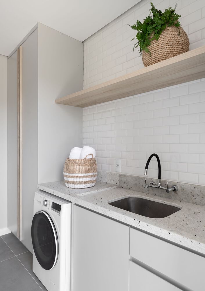 lavanderia branca com prateleira de madeira e planta decorativa
