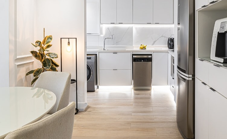 lavanderia branca organizada com poucos objetos e superfícies limpas