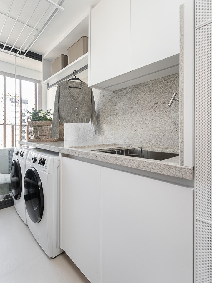 lavanderia branca com armários e espaço organizado para roupas
